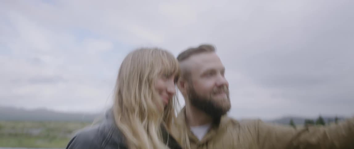 The man and woman take a picture together on a cloudy day
