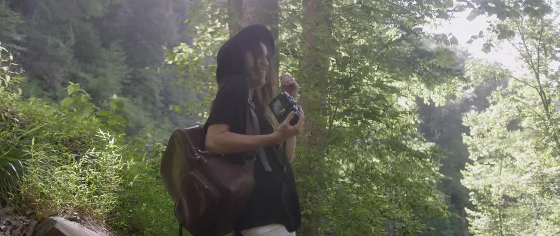 Woman Exploring Woods With Camera