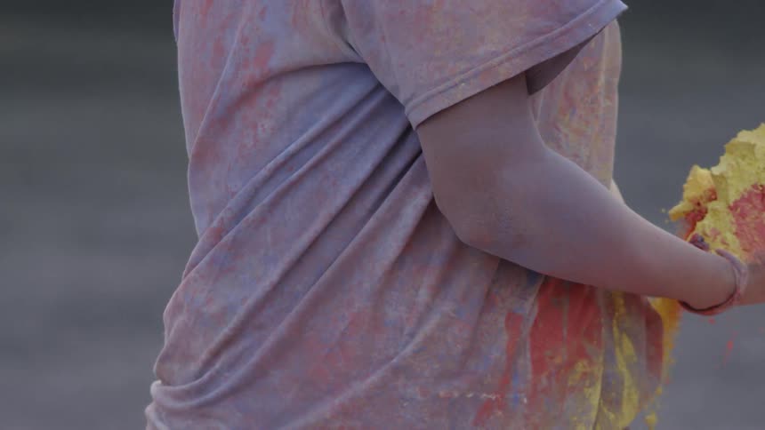 Person holds different colored powders and throws them