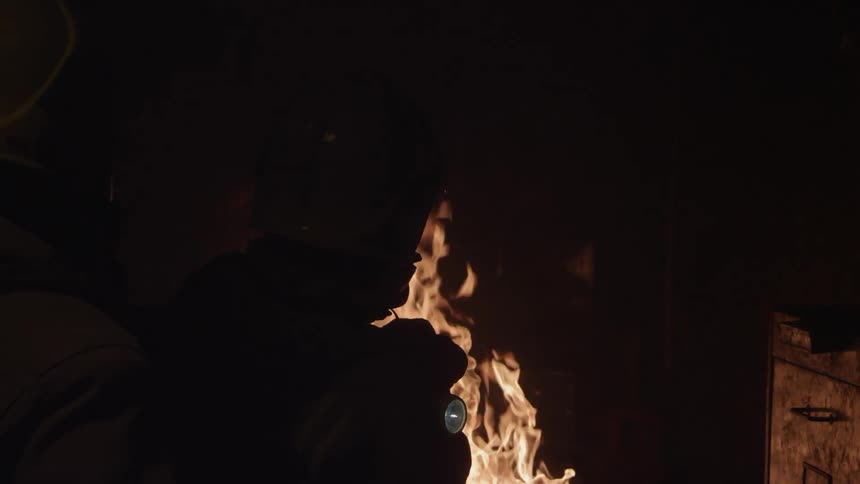 A firefighter sprays water on a home fire