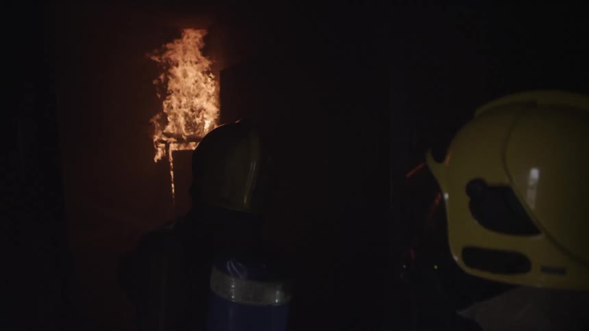 Firefighters fight a fire in the dark