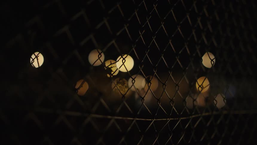Circular lights sit behind the chain link fence