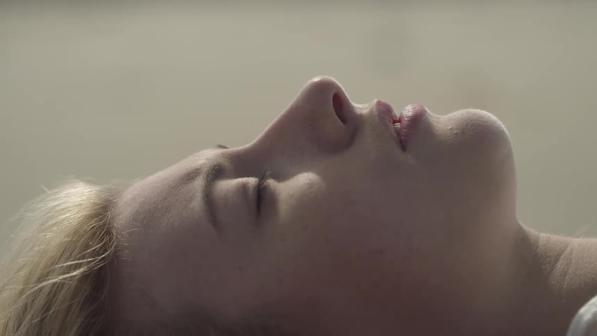 The woman lays down on the beach