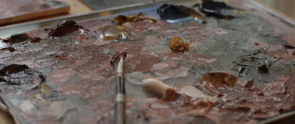 A paintbrush sits on top of a painting