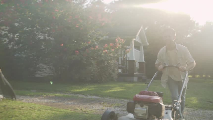 A man mows a front lawn