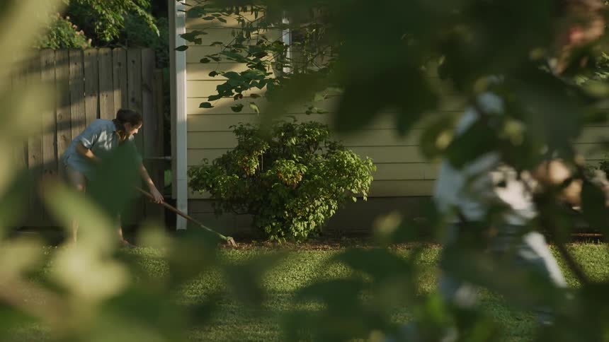 A man and woman do yard work on a summer day