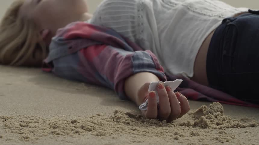 Woman Laying In Sand At The Beach