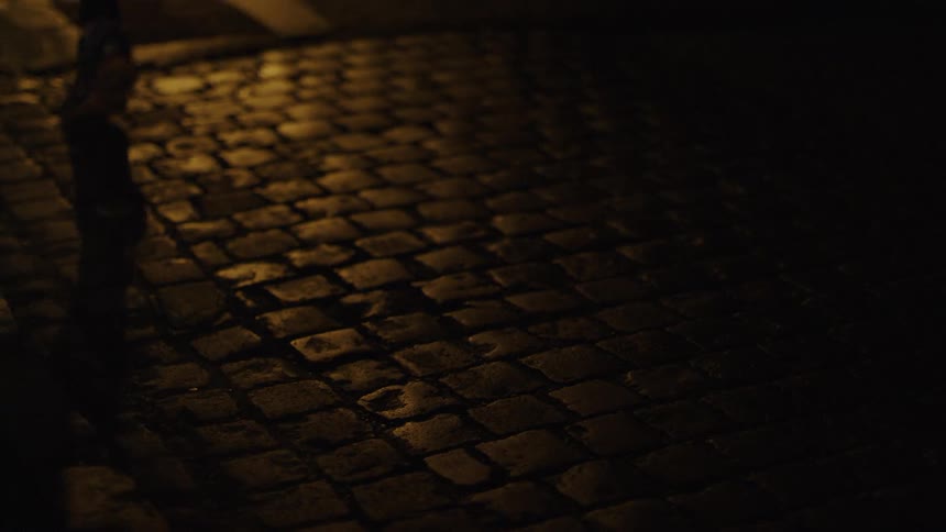 The person jogs over the cobblestone walkway