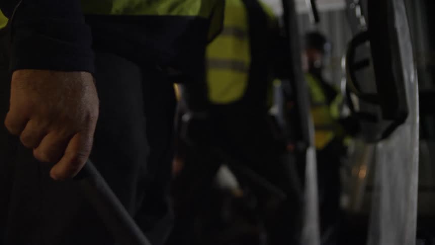 A policeman holds a baton behind a shield