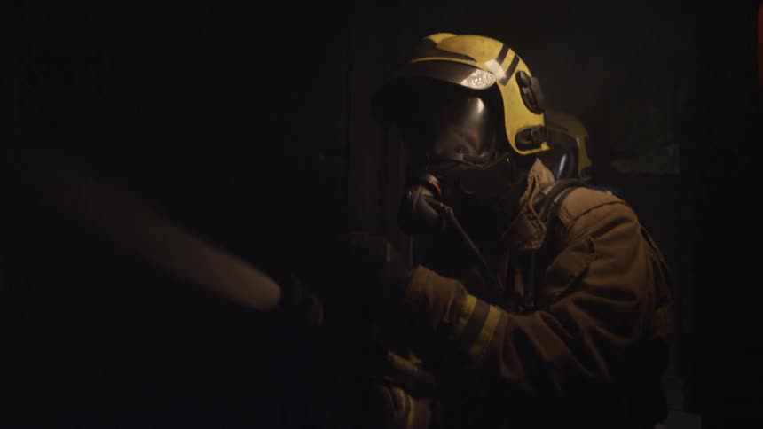 The firefighter sprays his hose