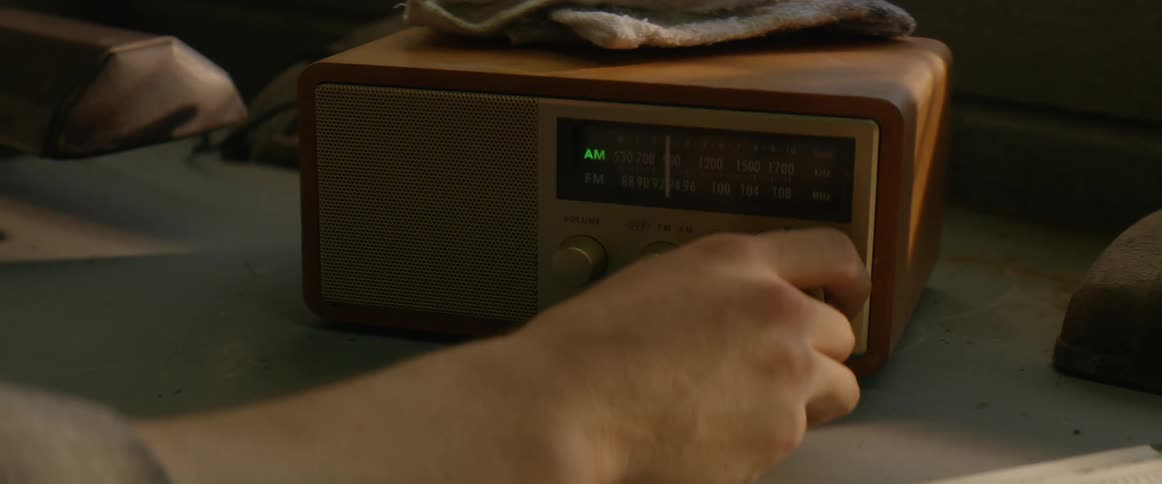 Person tunes a knob on a radio