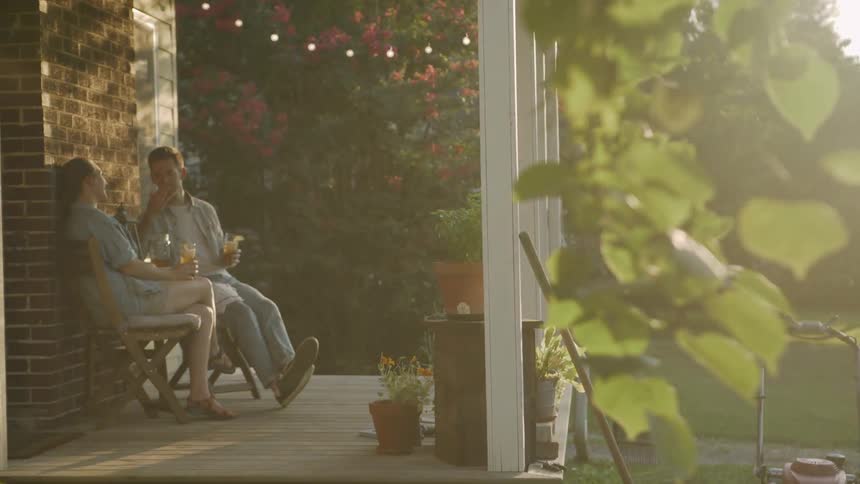 Man Blows a Kiss to Wife on Porch at Sunset
