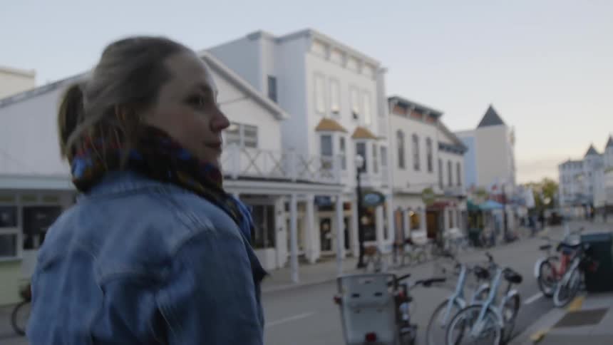 The woman walks down the street in town