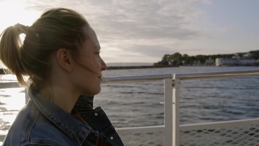The woman looks out over the water on a cloudy day