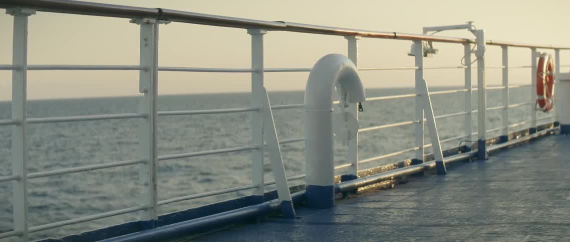 The railing of the boat shows a large ocean