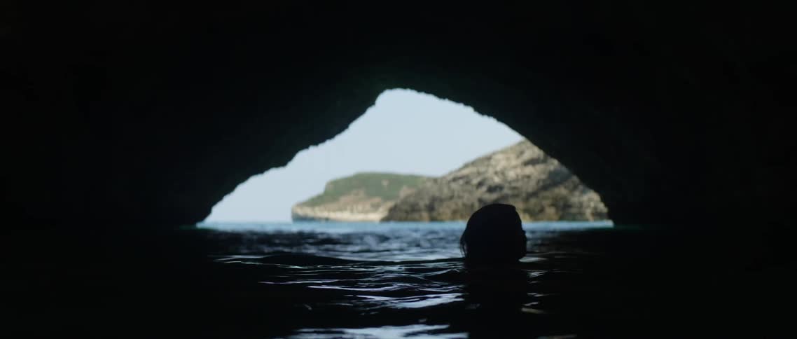 A woman treading water in a cave