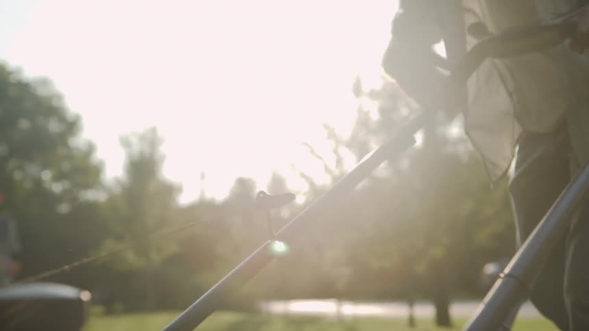 Man pulls a string to start a lawnmower
