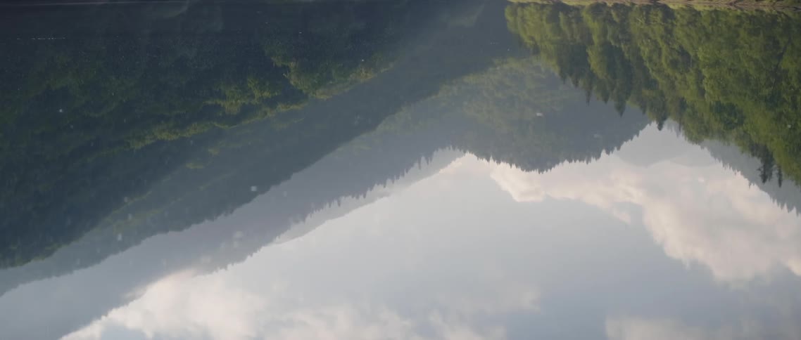 The water is reflecting the mountains