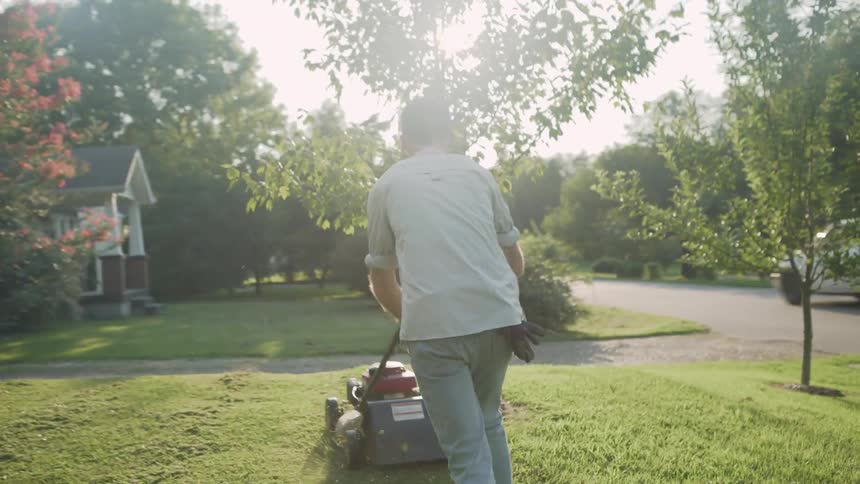 A man mows the front lawn