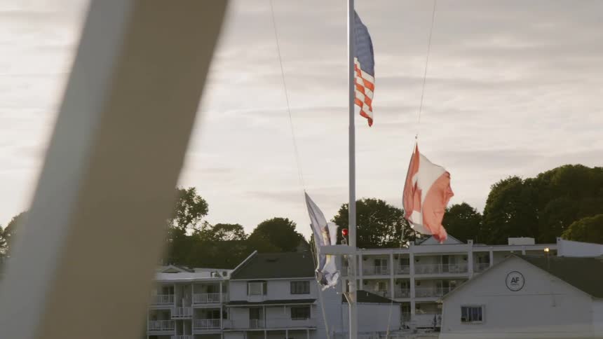 Flags billow in the wind on a ship mast