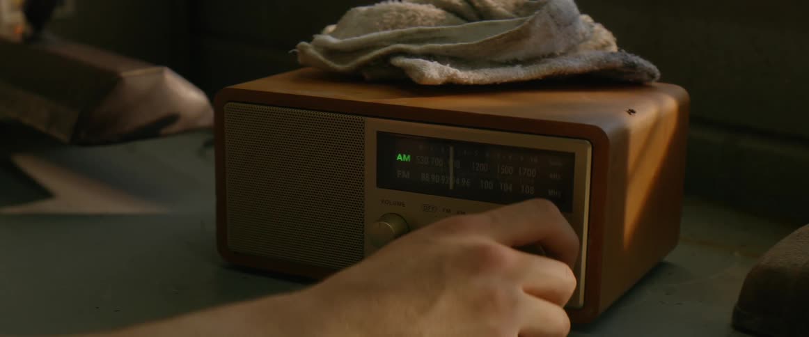 The person turns the knob on the radio