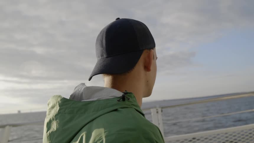 The man looks out over the water on the ship