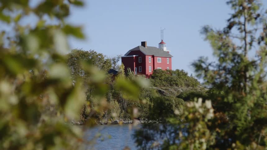 The red house on the hill has a tree next door