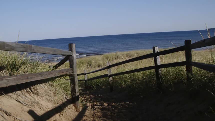 A sandy path leads to a beach