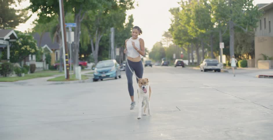 Woman runs through neighborhood with her dog