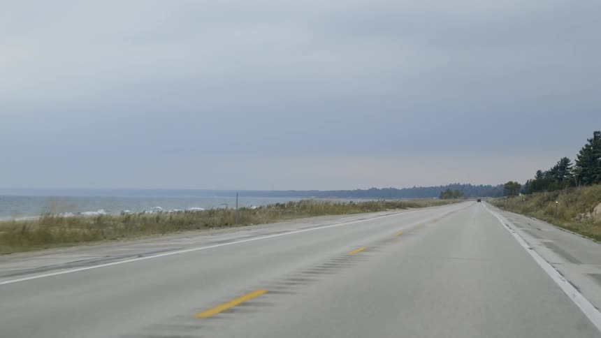 Country road next to a large body of water