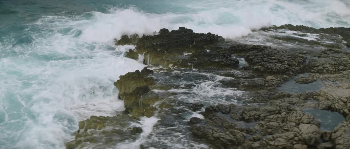 Ocean waves are crashing onto rocky shore