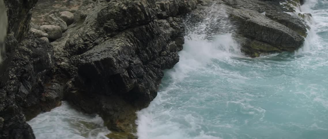 Ocean waves crash to a rocky shore