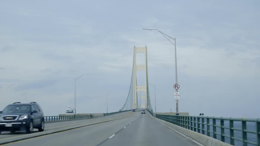 Cars travel over a bridge under the blue sky