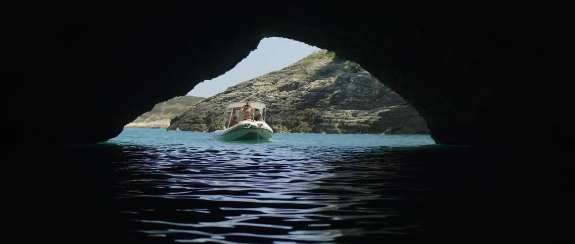 A boat enters a cave at the coast