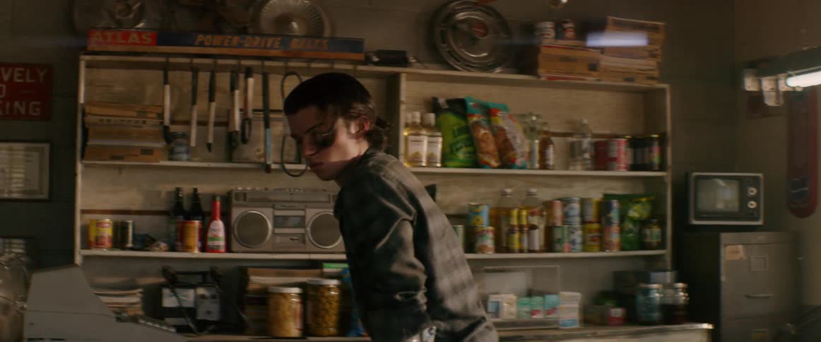 The man moves around the counter using crutches