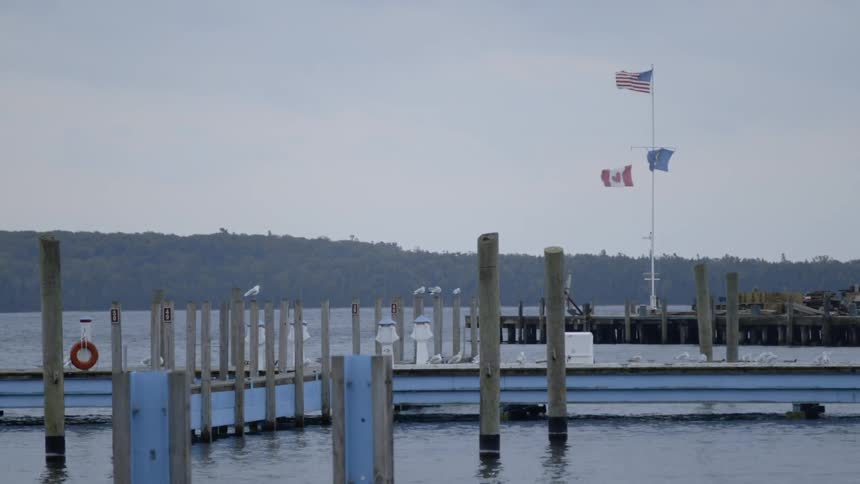 Flags billow in the wind on a lake dock