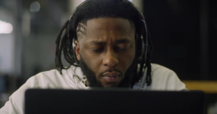 The man nods his head while using the laptop