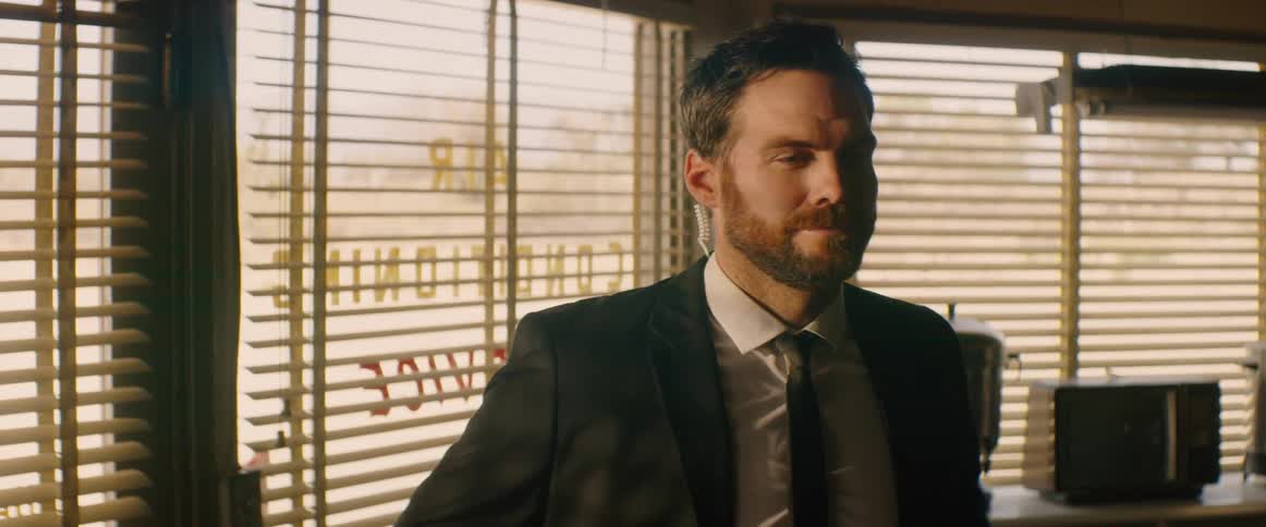 A man in a suit stands inside a store