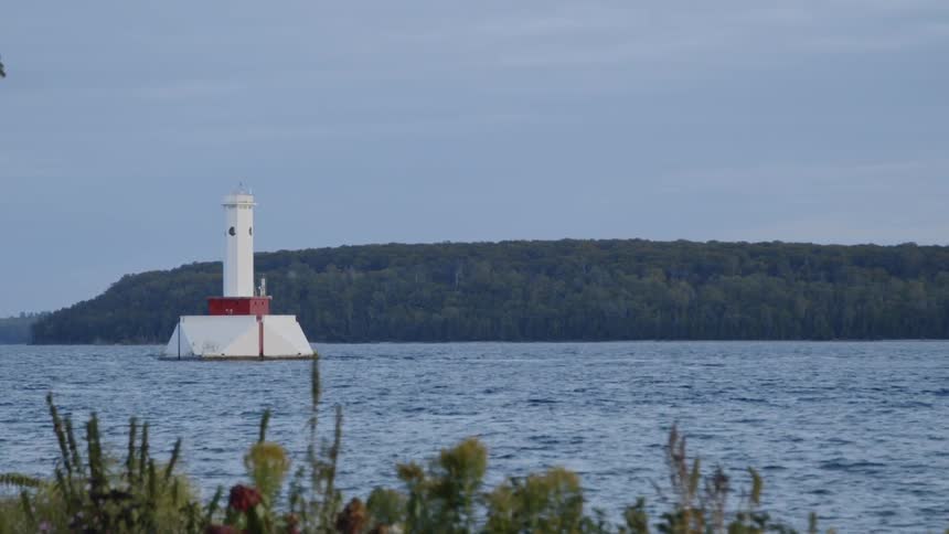 The lighthouse is by the shore ahead