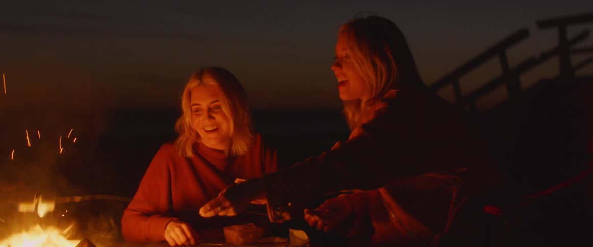 The woman roast marshmallows in the campfire