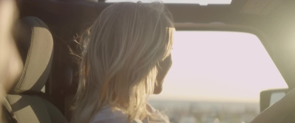 The woman rides in the car as she talks