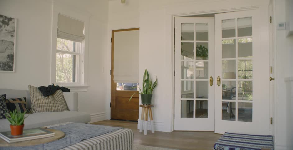 The living room is empty as the people approach the door outside