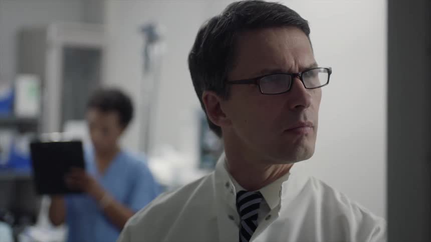 Doctor in a hospital reading results on a screen with interest