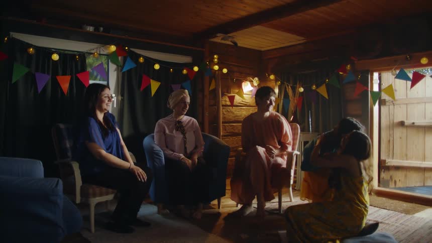 The women sit together at a party and one leaves