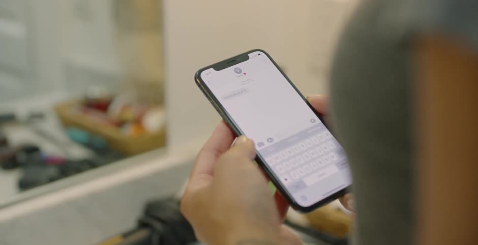 The woman uses a cell phone in her bathroom