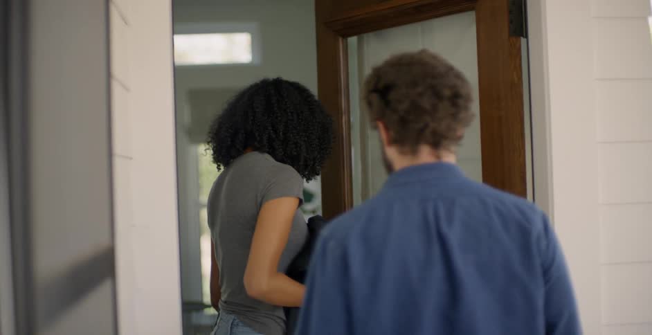 The woman holds her jacket as she closes the door