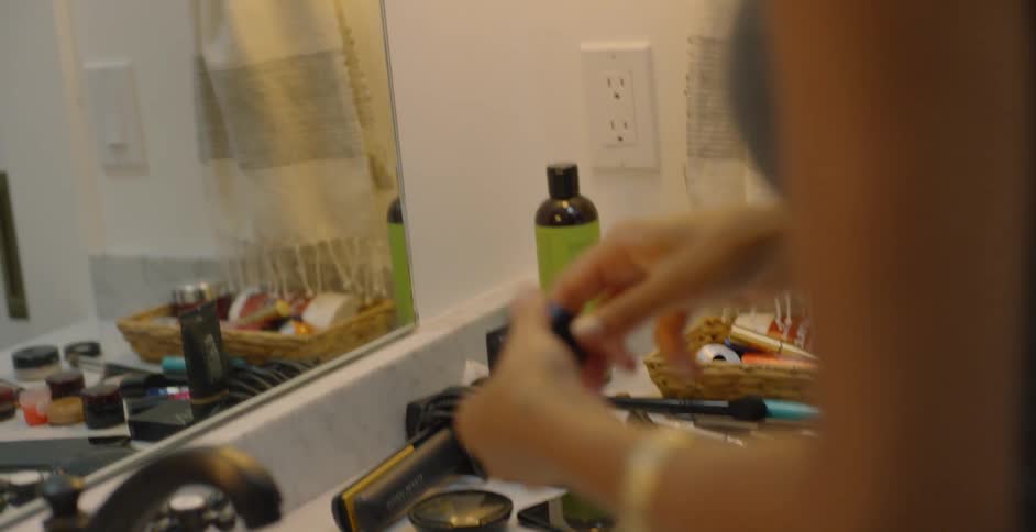 Woman in front of mirror using makeup