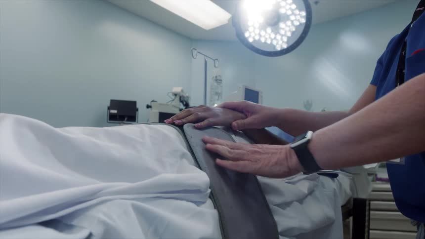 Nurses preparing a female patient for surgery in a hospital