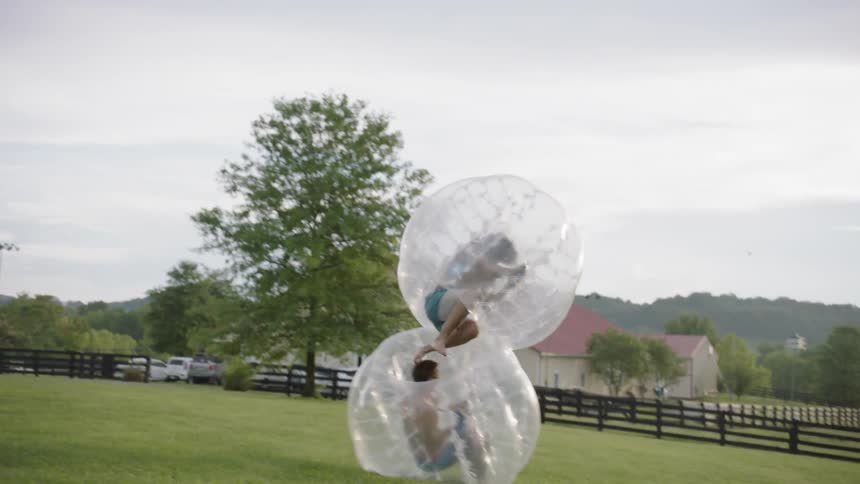 The two people collide and fall in inflatable balls
