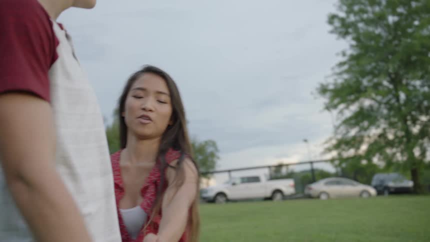 The girl talks with a man walking together in the yard
